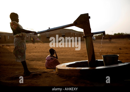 Children drawing water from a well in Malawi, Africa. These children live in an orphanage in Lilongwe. Stock Photo