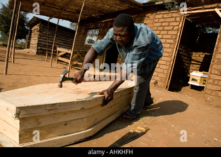 Carpenter making a coffin on 'Coffin Row', the coffin-making district in Lilongwe, Malawi Stock Photo