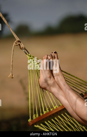 feet pictured relaxing on a hammock, illustrating someone chilling out, relaxing, taking time out and resting Stock Photo