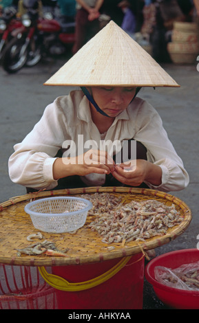 Woman cleaning seafood at Hong Gai Fish Market in Halong Bay Vietnam Stock Photo