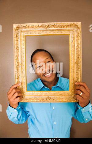 African man looking through picture frame Stock Photo