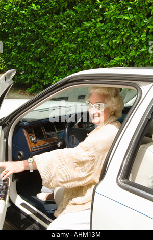 Senior woman getting into car Stock Photo