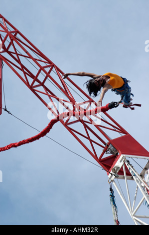 African American Woman bungee jumping from crane Stock Photo