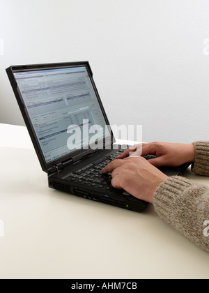 Hands of a man typing on a IBM laptop computer with office software on screen Stock Photo