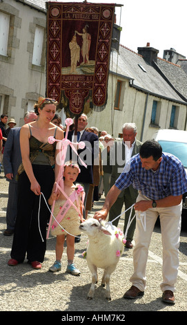 A tired small boy with his mother, grandfather and sheep in the village procession for the  annual Pardon, religious festival Stock Photo