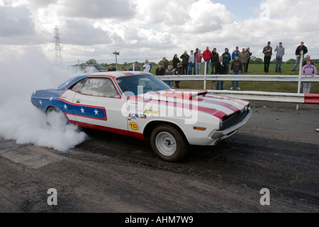 Heavily modified American muscle car doing a burnout prior to a drag race Stock Photo