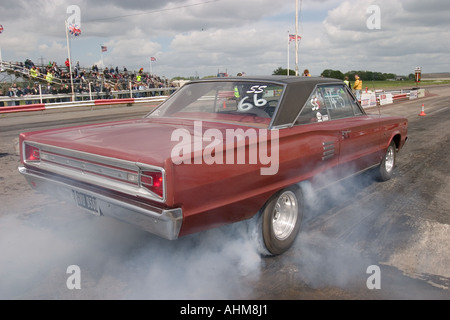 American muscle car doing burnout before start of drag race Stock Photo