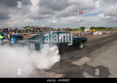 American muscle car doing burnout before start of drag race Stock Photo