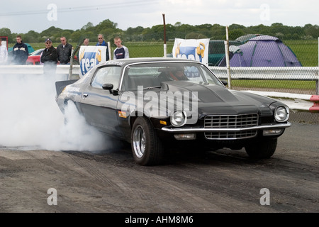 American muscle car doing burnout before start of drag race Stock Photo