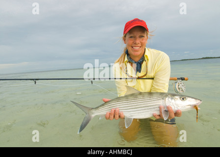 Florida Keys Happy woman fisherman landing and releasing bonefish while fly- fishing the flats of the Caribbean ocean Stock Photo