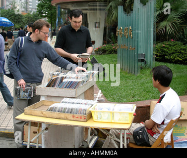 Tourists looking at DVD and CD street stall in Shanghai,China Stock Photo