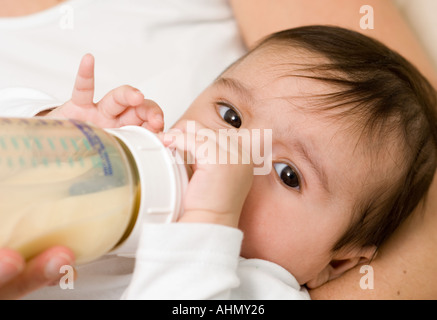 bottle fed 4 month old baby with mother Stock Photo