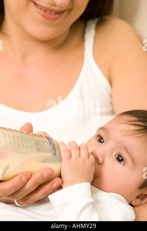 bottle fed 4 month old baby with mother Stock Photo