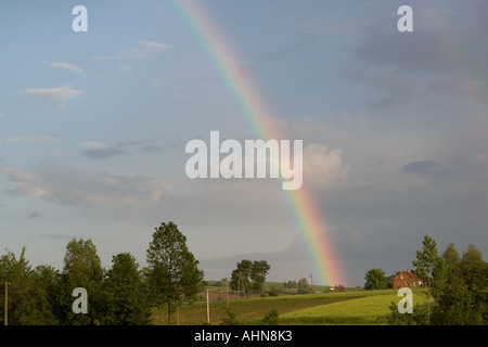 rainbow shining after summer thunderstorm over fields Stock Photo