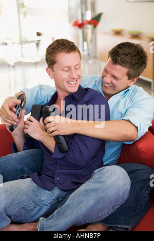 Gay couple fighting over remote controls Stock Photo