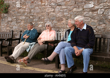 UK Devon Topsham The Underway Grubb and Hobday families relaxing on riverside bench Stock Photo