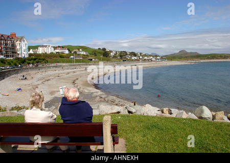 UK Wales Gwynedd Criccieth people sat on bench overlooking the beach Stock Photo