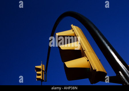 A set of yellow traffic lights in Spain against a deep blue sky Stock Photo