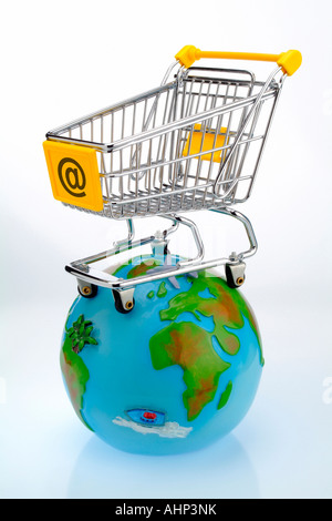 An empty shopping cart with @ on it, on a globe Stock Photo
