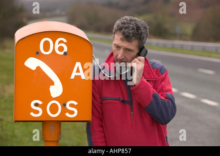 a stranded motorist using an SOS phone Stock Photo - Alamy