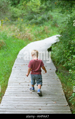 Small child walking on pathway leading away childhood Stock Photo