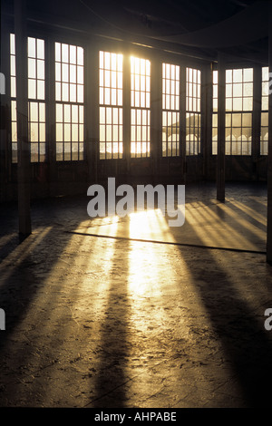 A large empty room with golden sunlight streaming in Studio by the sea Stock Photo