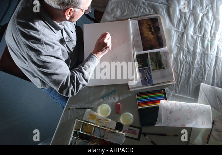 An artist sketches on a pad before painting during a class Stock Photo