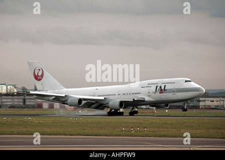 Horizontal view of a Japanese Airline (JAL) Boeing 747 at the moment of impact landing on a runway. Stock Photo