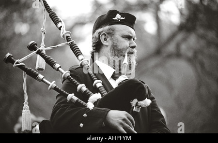 Man playing bagpipes in head and shoulder monochrome shot. Stock Photo