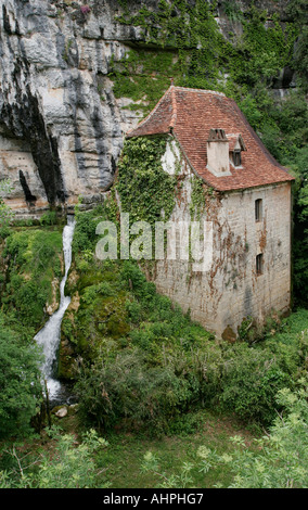 House under a cliff with waterfall, France Stock Photo