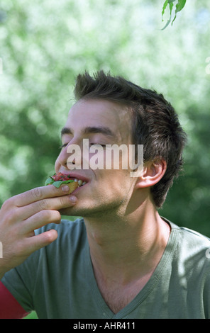 Young man eating food Stock Photo