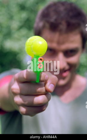 Young man aiming water pistol. Stock Photo