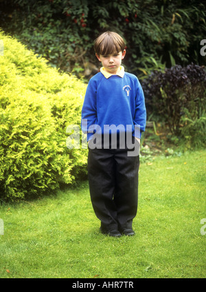 Young boy wearing school uniform looking sad, England, UK Stock Photo