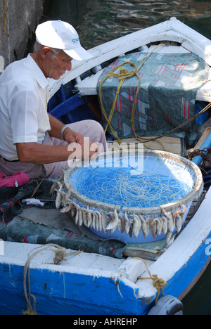 Fisherman baiting fish hooks, Saranda Marina, Saranda, Vlorë County, Albania Stock Photo