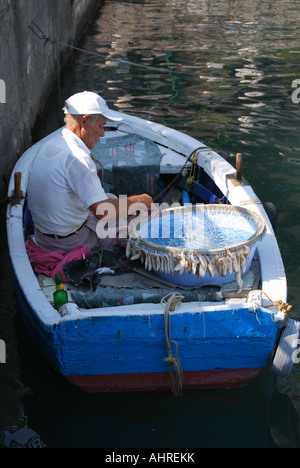 Fisherman baiting fish hooks, Saranda Marina, Saranda, Vlorë County, Albania Stock Photo