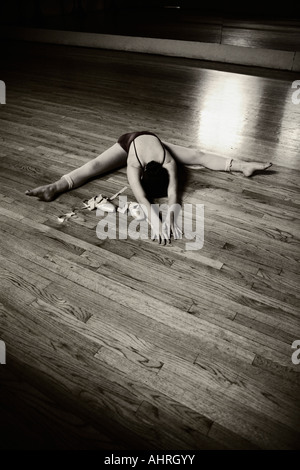 a ballet dancer stretching on the floor in the ballet studio Stock Photo