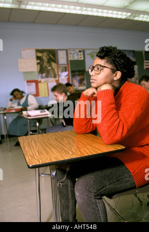 A black female 15 year old student wearing glasses in a day dreaming state of mind Stock Photo