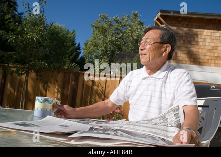 Senior Man Reading Paper, Drinking Coffee Stock Photo