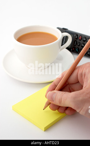 writing a reminder on a post it note Stock Photo