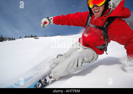 Austria, Saalbach, man skiing down mountain slope, smiling Stock Photo