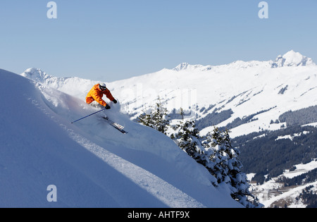 Austria, Saalbach, man skiing down slope, mountains in distance Stock Photo