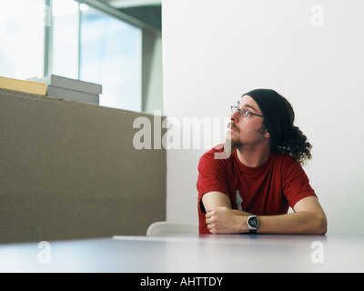 Young man sitting at desk portrait Stock Photo