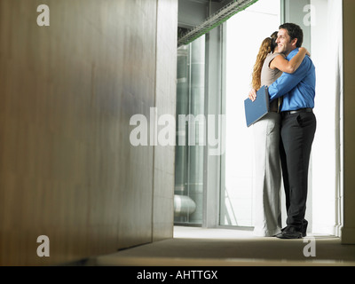 A woman hugging a man in a hallway