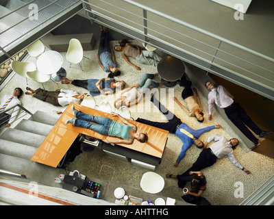 Businesspeople lying on the floor in an office Stock Photo