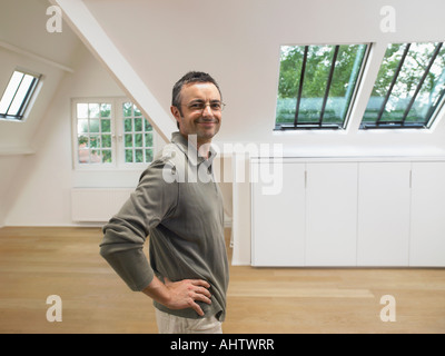 Portrait of man looking at camera inside empty white loft. Stock Photo