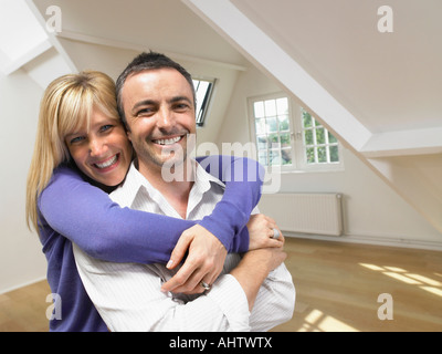 Happy couple in an embrace in empty loft. Stock Photo