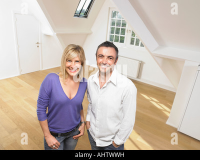 Couple standing in empty loft. Stock Photo