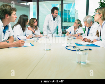 Business meeting of a group of doctors in a conference room around a table. Stock Photo