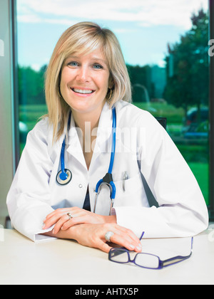 Portrait of smiling female doctor at her desk. Stock Photo