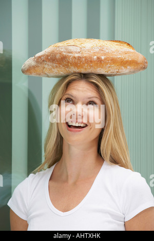 Young woman with loaf of bread on head.